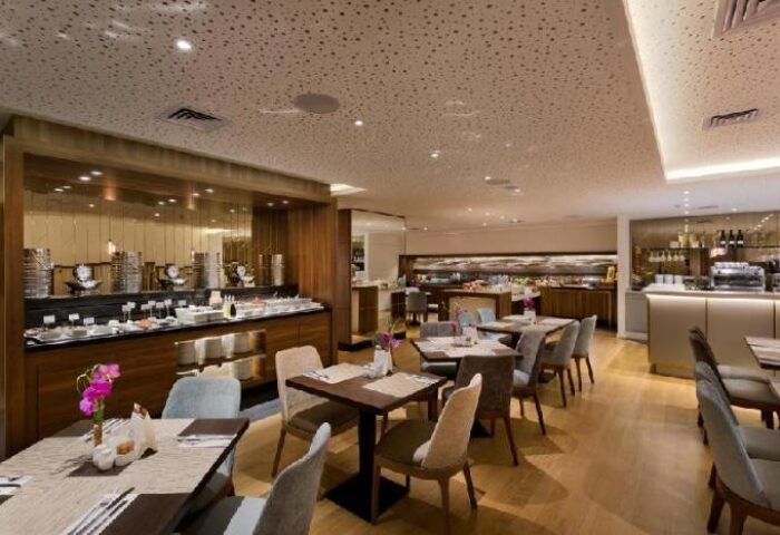 Isrotel Tower Hotel dining room. Buffet, tables, and chairs in a modern, gay-friendly hotel. Interior of a Tel Aviv hotel.