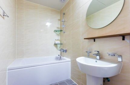 Bathroom interior at Itaewon A One Hotel, a gay-friendly hotel. Features a tub, sink, mirror, and tiled walls. Ideal for gay travel.