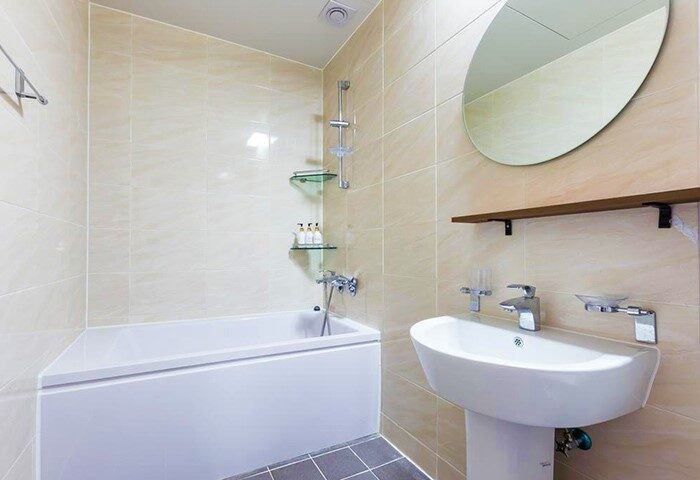Bathroom interior at Itaewon A One Hotel, a gay-friendly hotel. Features a tub, sink, mirror, and tiled walls. Ideal for gay travel.