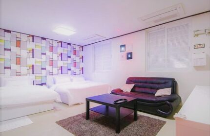 Itaewon A One Hotel room. Gay-friendly hotel with two beds, sofa, table, and colorful wall design. Modern lodging in Itaewon, South Korea.