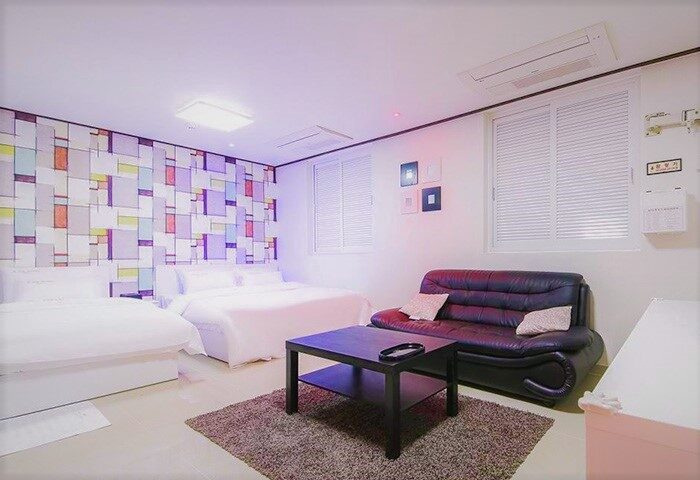 Itaewon A One Hotel room. Gay-friendly hotel with two beds, sofa, table, and colorful wall design. Modern lodging in Itaewon, South Korea.