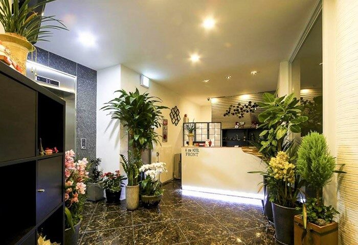 Itaewon A One Hotel's lobby, a gay-friendly hotel. Features plants, a front desk, and modern decor. Great for gay travel in Seoul, South Korea.
