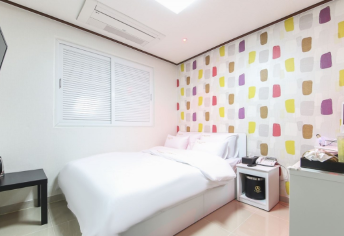 Itaewon A One Hotel room. Gay-friendly hotel in Seoul, South Korea. Clean, modern interior with colorful wall design, bed, desk, and TV.