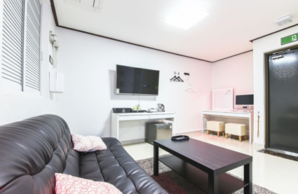 Itaewon A One Hotel guest room. Gay-friendly hotel in Itaewon, Seoul. Features a black sofa, TV, desk, and modern decor. Comfortable stay.