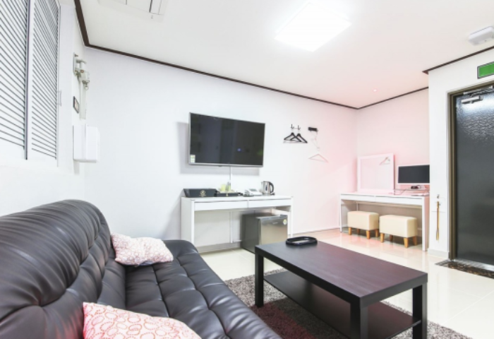 Itaewon A One Hotel guest room. Gay-friendly hotel in Itaewon, Seoul. Features a black sofa, TV, desk, and modern decor. Comfortable stay.