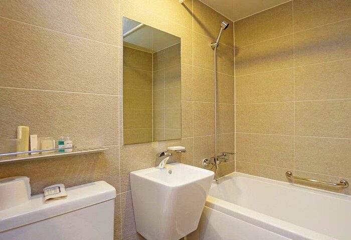 Bathroom at Itaewon Crown Hotel, a gay-friendly hotel. Features a tub, sink, mirror, and toilet. Ideal for gay travelers in Itaewon, Korea.