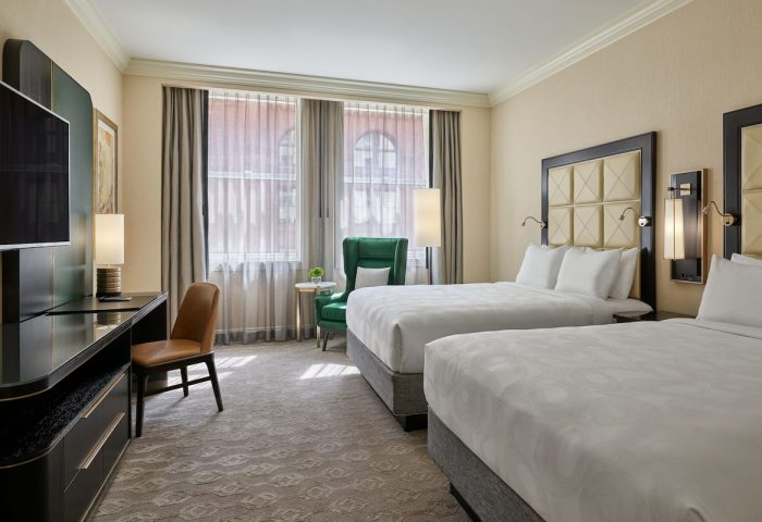 JW Marriott Chicago gay-friendly hotel room. Two beds with white linens, desk, chair, and window. Luxury accommodations in Chicago.