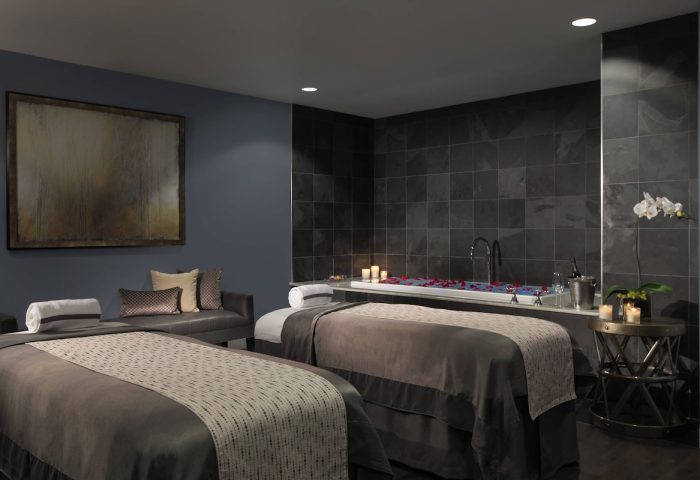 JW Marriott Chicago gay-friendly hotel's spa. Two massage tables face a tub with rose petals and candles. Relaxing gay travel experience.