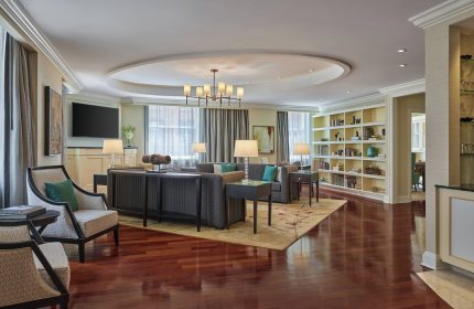 JW Marriott Chicago gay-friendly hotel suite. Living room with sofas, chairs, bookshelf, and wood floors. Luxury gay travel.