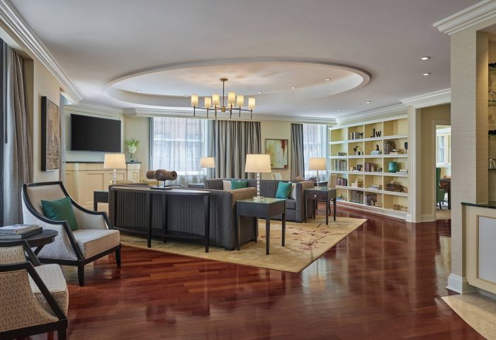 JW Marriott Chicago gay-friendly hotel suite. Living room with sofas, chairs, bookshelf, and wood floors. Luxury gay travel.