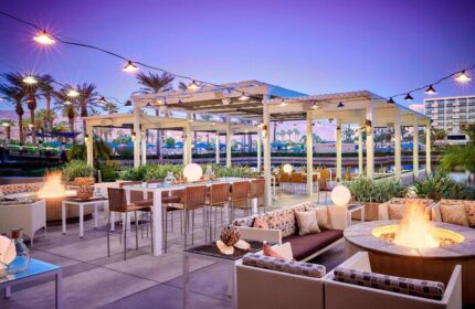 JW Marriott Desert Springs Resort & Spa outdoor patio at dusk. Gay-friendly hotel with fire pits, seating, and lights. Palm Springs getaway.