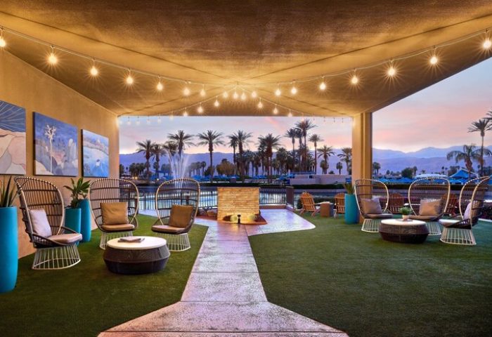JW Marriott Desert Springs Resort & Spa patio. Stylish seating, palm trees, & mountain views. Gay-friendly hotel for relaxing travel.