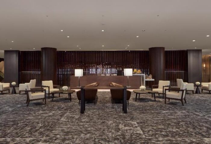 Lobby seating area at the gay-friendly JW Marriott Hotel Seoul. Elegant design with chairs, tables, and a reception desk. Upscale travel.