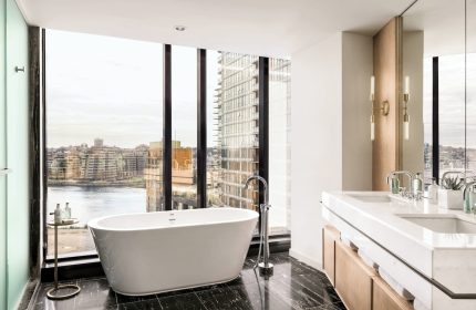JW Marriott Parq Vancouver gay-friendly hotel bathroom. Bathtub with city view. Upscale design, marble floor, and modern fixtures.
