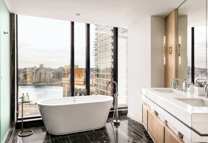 JW Marriott Parq Vancouver gay-friendly hotel bathroom. Bathtub with city view. Upscale design, marble floor, and modern fixtures.