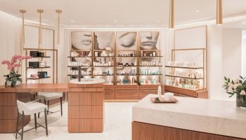 JW Marriott Parq Vancouver's spa. Beauty products are displayed on shelves with images of faces above. Gay-friendly hotel with nice amenities.