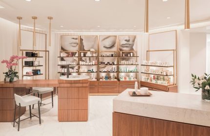 JW Marriott Parq Vancouver's spa. Beauty products are displayed on shelves with images of faces above. Gay-friendly hotel with nice amenities.