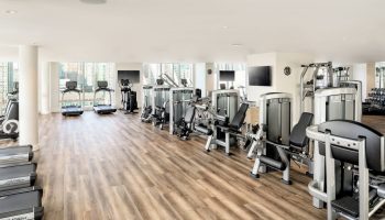 JW Marriott Parq Vancouver gym. Treadmills, weights, and exercise machines in a well-lit, modern fitness center. Gay-friendly hotel.