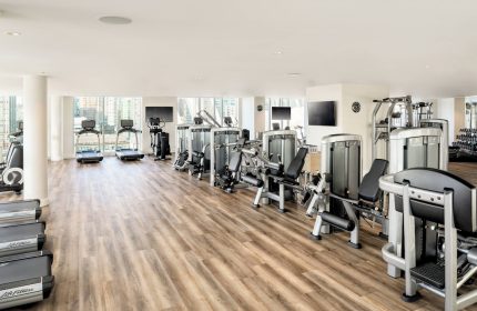 JW Marriott Parq Vancouver gym. Treadmills, weights, and exercise machines in a well-lit, modern fitness center. Gay-friendly hotel.