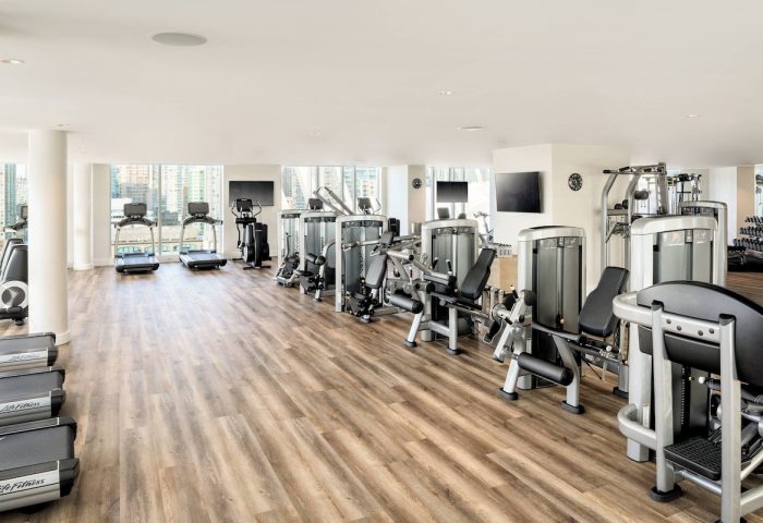 JW Marriott Parq Vancouver gym. Treadmills, weights, and exercise machines in a well-lit, modern fitness center. Gay-friendly hotel.