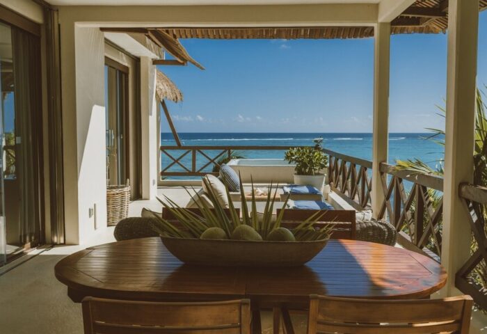 Gay-friendly Jashita Hotel view. Ocean view from a balcony with a wooden table & chairs. Perfect for gay men's travel in a luxury hotel.