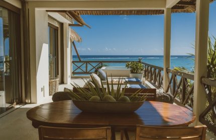 Gay-friendly Jashita Hotel view. Ocean view from a balcony with a wooden table & chairs. Perfect for gay men's travel in a luxury hotel.
