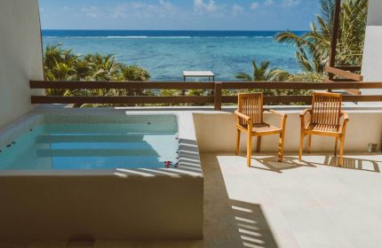 Jashita Hotel's gay-friendly rooms offer ocean views. Balcony with jacuzzi, chairs, and turquoise sea. Ideal for gay travel and relaxation.