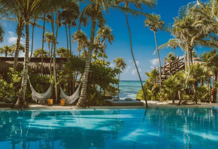 Jashita Hotel pool view. Gay-friendly hotel with hammocks, palm trees, and ocean access. A tropical paradise for gay men's travel.
