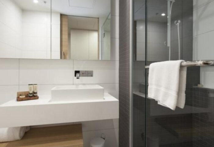 Modern bathroom at Jasper Boutique Hotel, a gay-friendly hotel. Features include a shower, sink, and toiletries. Great for gay travel.