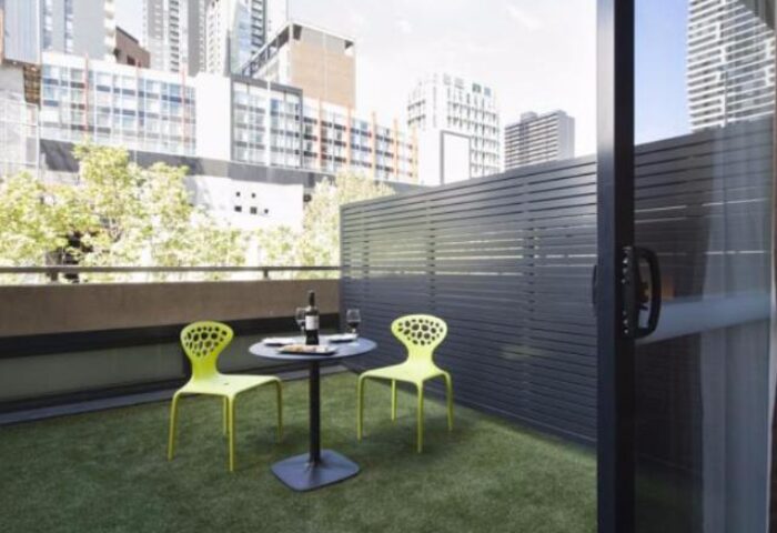 Jasper Boutique Hotel balcony with table, chairs, and city view. Gay-friendly hotel offering stylish accommodations for gay men travelers.