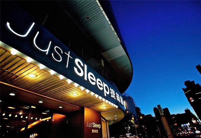 Just Sleep Hotel Ximending facade at night. A gay-friendly hotel in Taipei, Taiwan, offering comfortable accommodations for LGBTQ+ travelers.