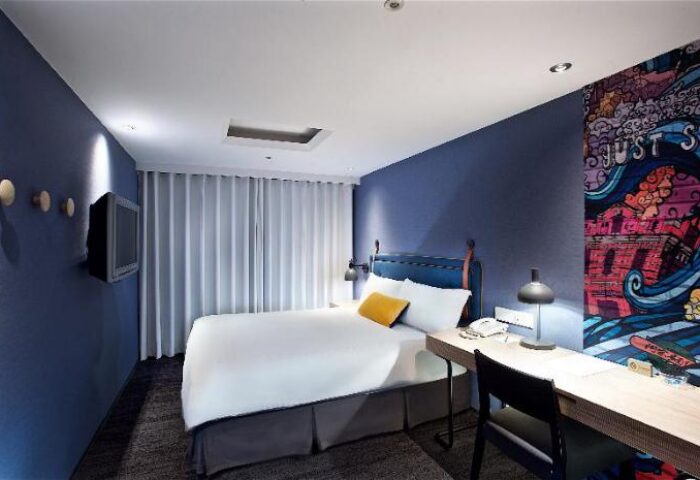 Just Sleep Hotel Ximending room. Modern design, blue walls, desk, and bed. Gay-friendly hotel in Taipei for LGBT travelers.