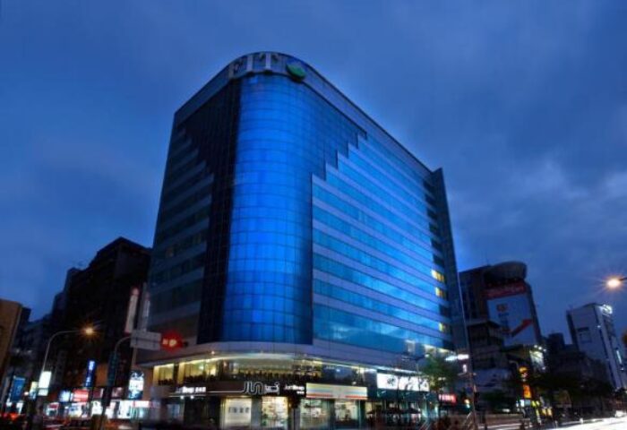 Just Sleep Hotel Ximending at night. Gay-friendly hotel in Taipei, Taiwan. Modern building with blue glass facade. Great location for gay travelers.