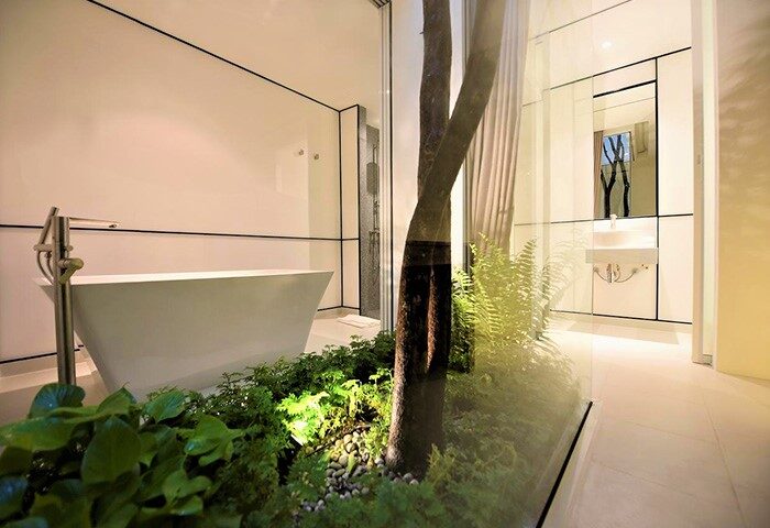 K Maison Lanna Boutique Hotel bathroom. Gay-friendly hotel with bathtub, tree, and modern design. Chiang Mai luxury for gay travelers.