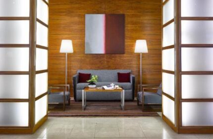 K+K Hotel Fenix lobby. Gay-friendly, pet-friendly hotel with modern decor. Seating area with sofa, chairs, and art. Welcoming space for travelers.