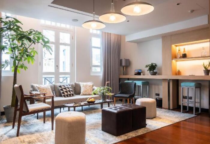 KēSa House, Oakwood's gay-friendly hotel. Modern living room with sofa, chairs, and bar area. Perfect for gay travelers seeking comfort.