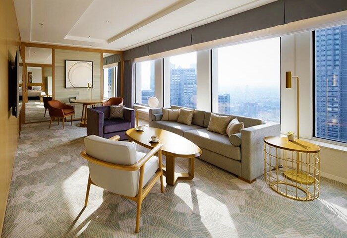 Gay-friendly Keio Plaza Hotel Tokyo suite. Modern interior with city view, sofa, chairs, and tables. Luxury accommodations for gay travelers.