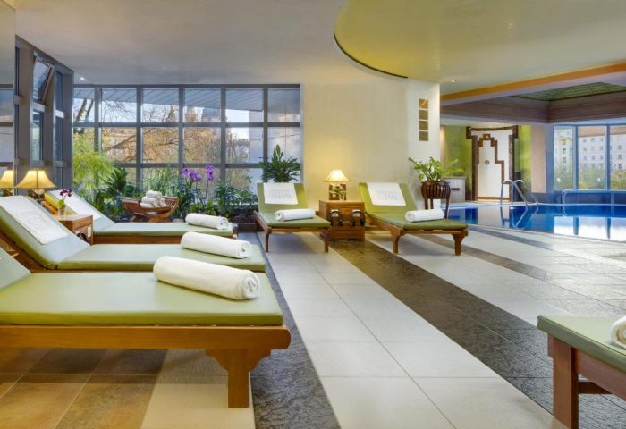 Kempinski Hotel Corvinus Budapest's spa area with sunbeds, towels, plants, and a pool. Gay-friendly, pet-friendly hotel.