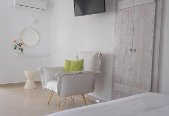 Keti Hotel room: Interior view of a gay-friendly hotel. Features a chair, TV, closet, and minimalist decor. Ideal for gay men travel.