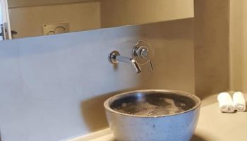 Keti Hotel's bathroom. Modern design, round sink, mirror, towels. Gay-friendly hotel, stylish interior. Ideal for gay travelers.