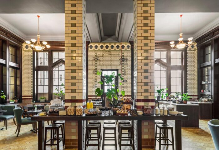 Interior of the gay-friendly Kimpton Clocktower Hotel. Breakfast buffet with pastries, juice, and coffee. Stylish, tiled pillars.