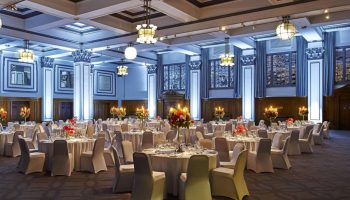Kimpton Clocktower Hotel ballroom. Round tables with white linens, floral centerpieces, and candles. Gay-friendly hotel event space.