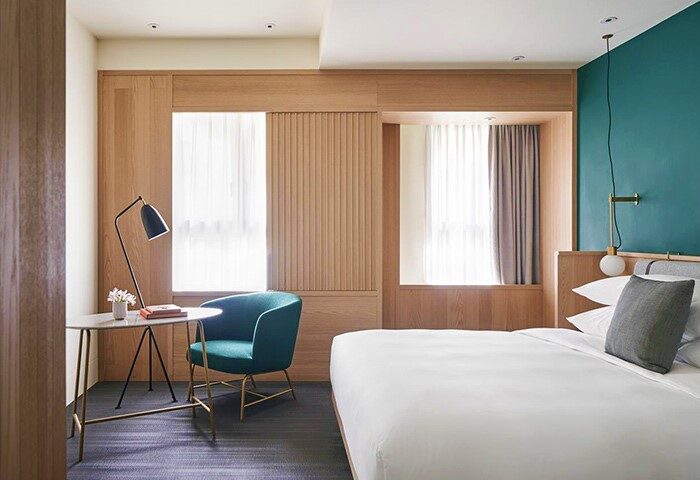 Kimpton Da An Hotel room: bed, chair, desk, and window. A gay-friendly hotel in Taipei, Taiwan for gay travelers.