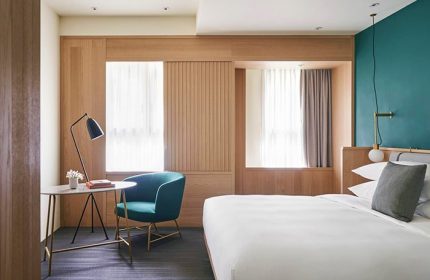 Kimpton Da An Hotel room: bed, chair, desk, and window. A gay-friendly hotel in Taipei, Taiwan for gay travelers.