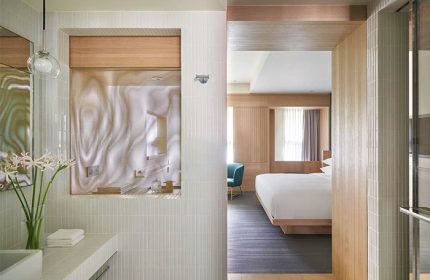 Kimpton Da An Hotel bathroom. Gay-friendly hotel room view with a bed, chair, and bathroom sink. Modern design for gay travel.