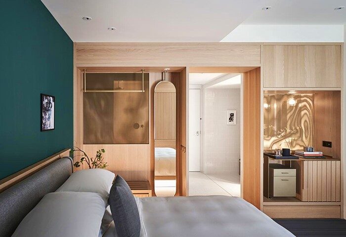 Kimpton Da An Hotel room. Modern, gay-friendly hotel design with wood accents, a green wall, and view into the bathroom. Ideal for gay travel.