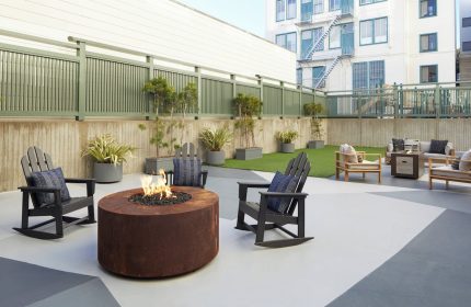 Kimpton Hotel Enso's outdoor patio with a fire pit and Adirondack chairs. This gay-friendly hotel offers a relaxing space for travelers.