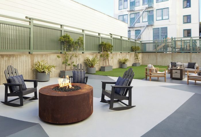 Kimpton Hotel Enso's outdoor patio with a fire pit and Adirondack chairs. This gay-friendly hotel offers a relaxing space for travelers.