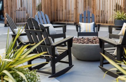 Kimpton Hotel Enso outdoor patio with rocking chairs around a fire pit. A gay-friendly hotel offering a welcoming space for relaxation.