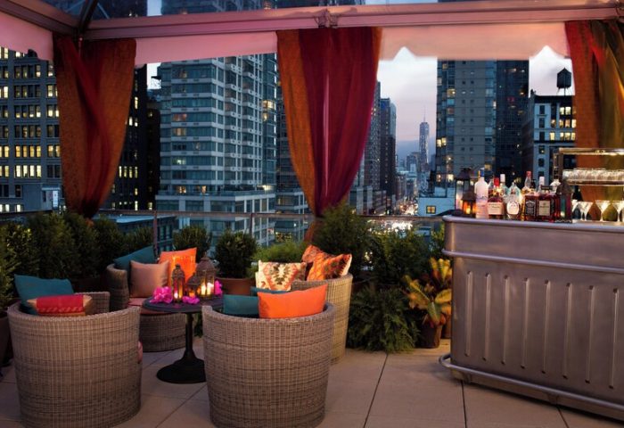 Kimpton Hotel Eventi rooftop bar with city views. Gay-friendly hotel with outdoor seating, drinks, and plants. Great spot for gay travelers.